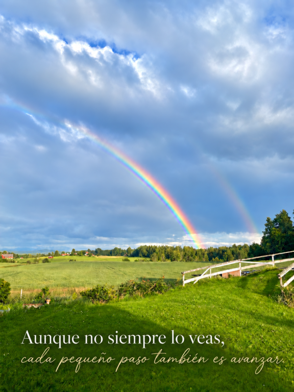 Aunque no siempre lo veas, cada pequeño paso también es avanzar. Frase sobre un paisaje de campo verde con arcoíris